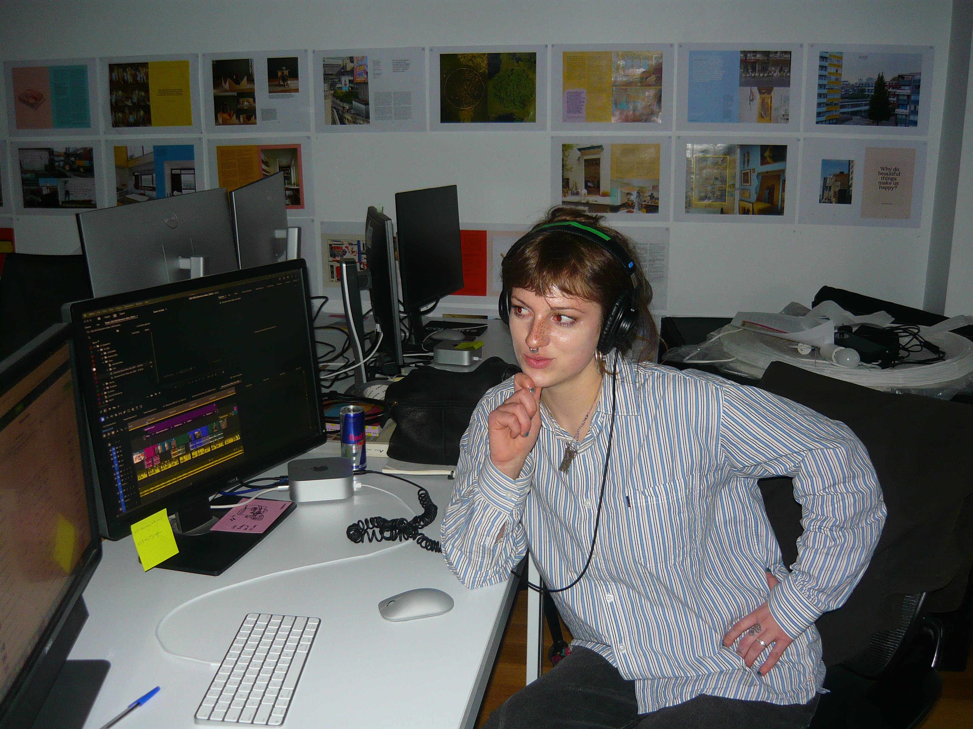 Collarts screen and media student posing at computer desk with headphones on while doing a media internship