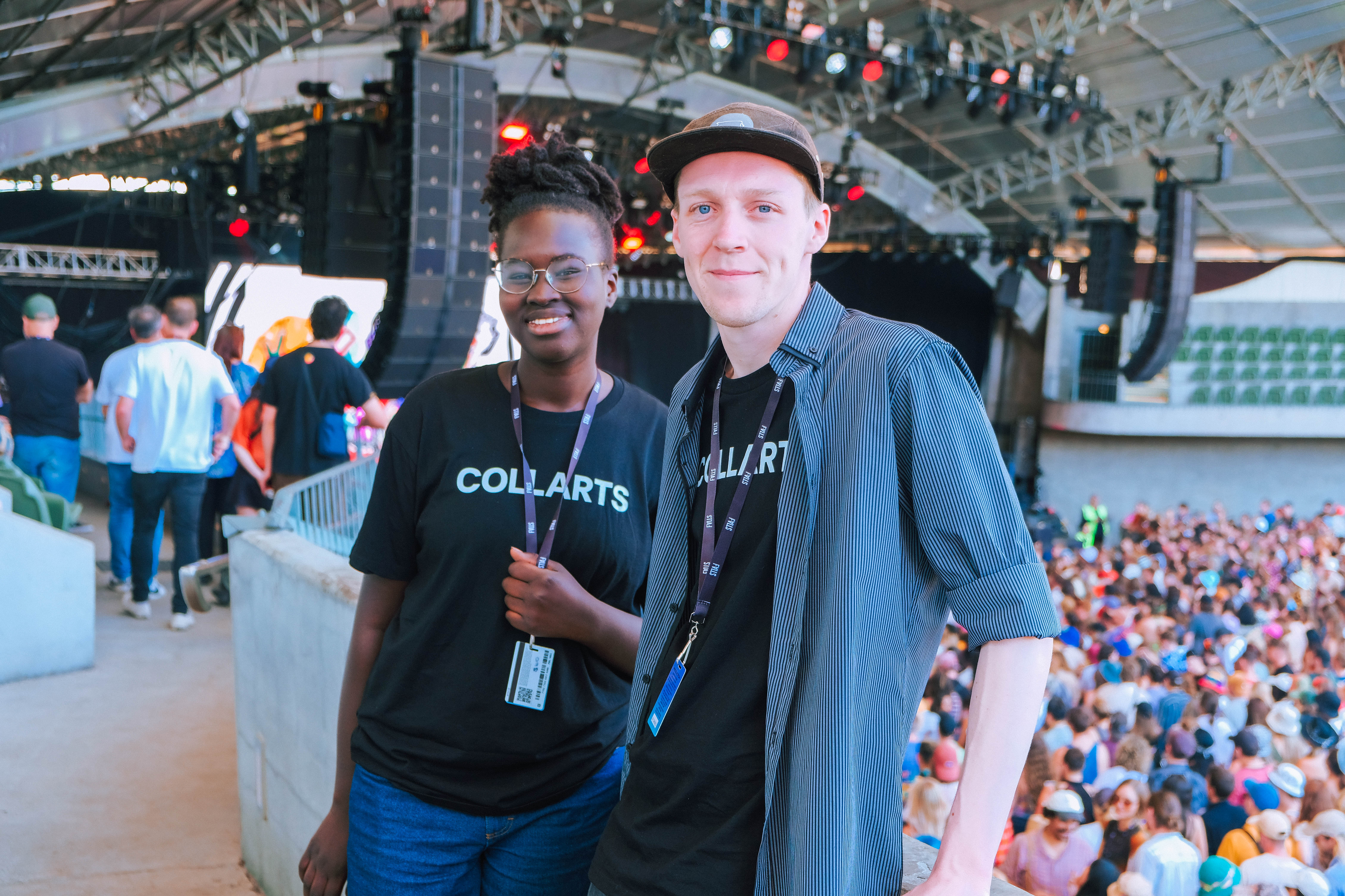 Two smiling Collarts Event Management students working at a music festival