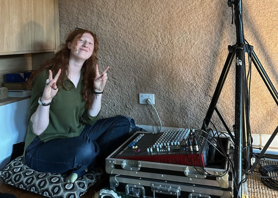 Collarts student smiling and sitting on the floor with her audio production equipment