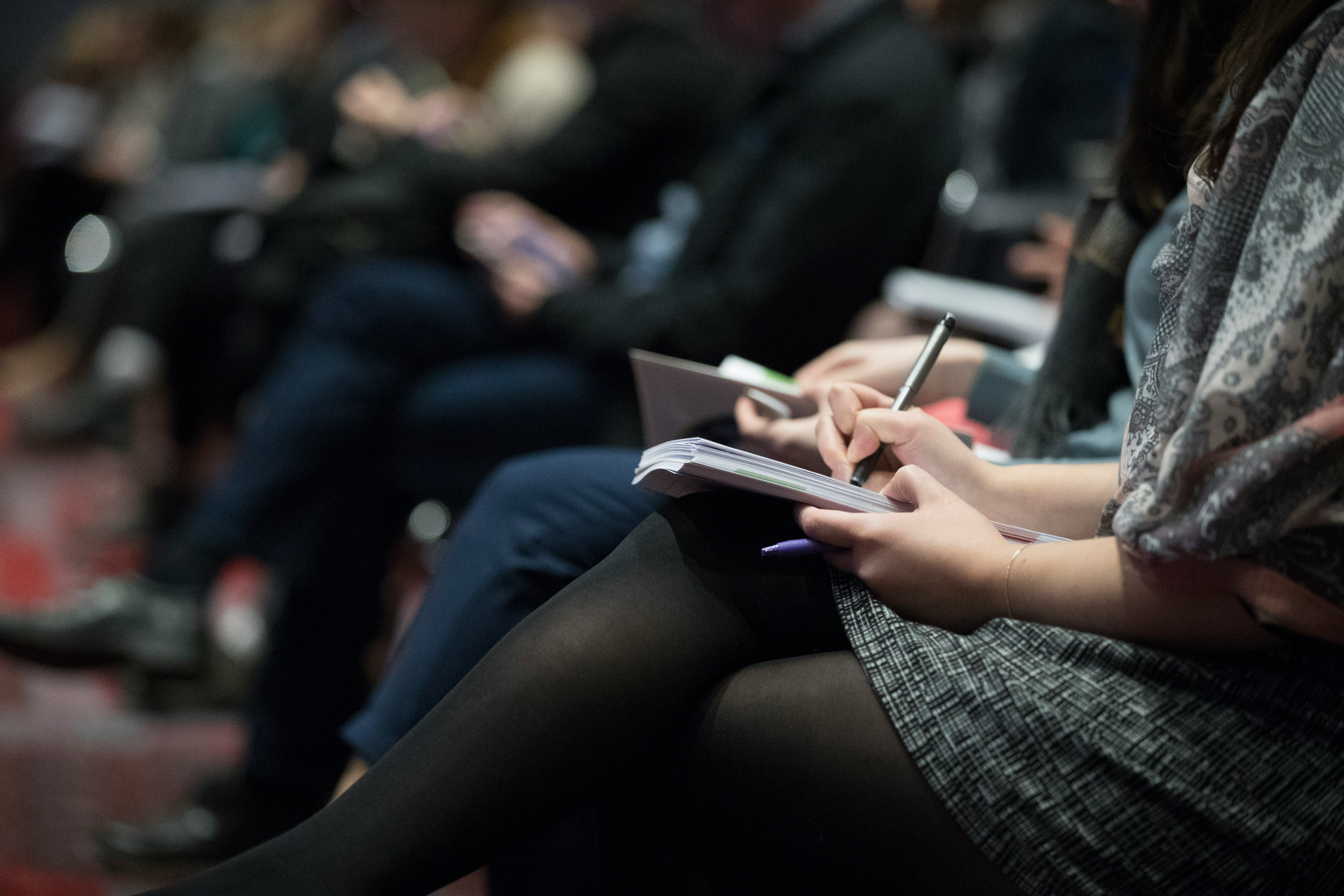 close up of woman's lap holding a notebook and writing in it