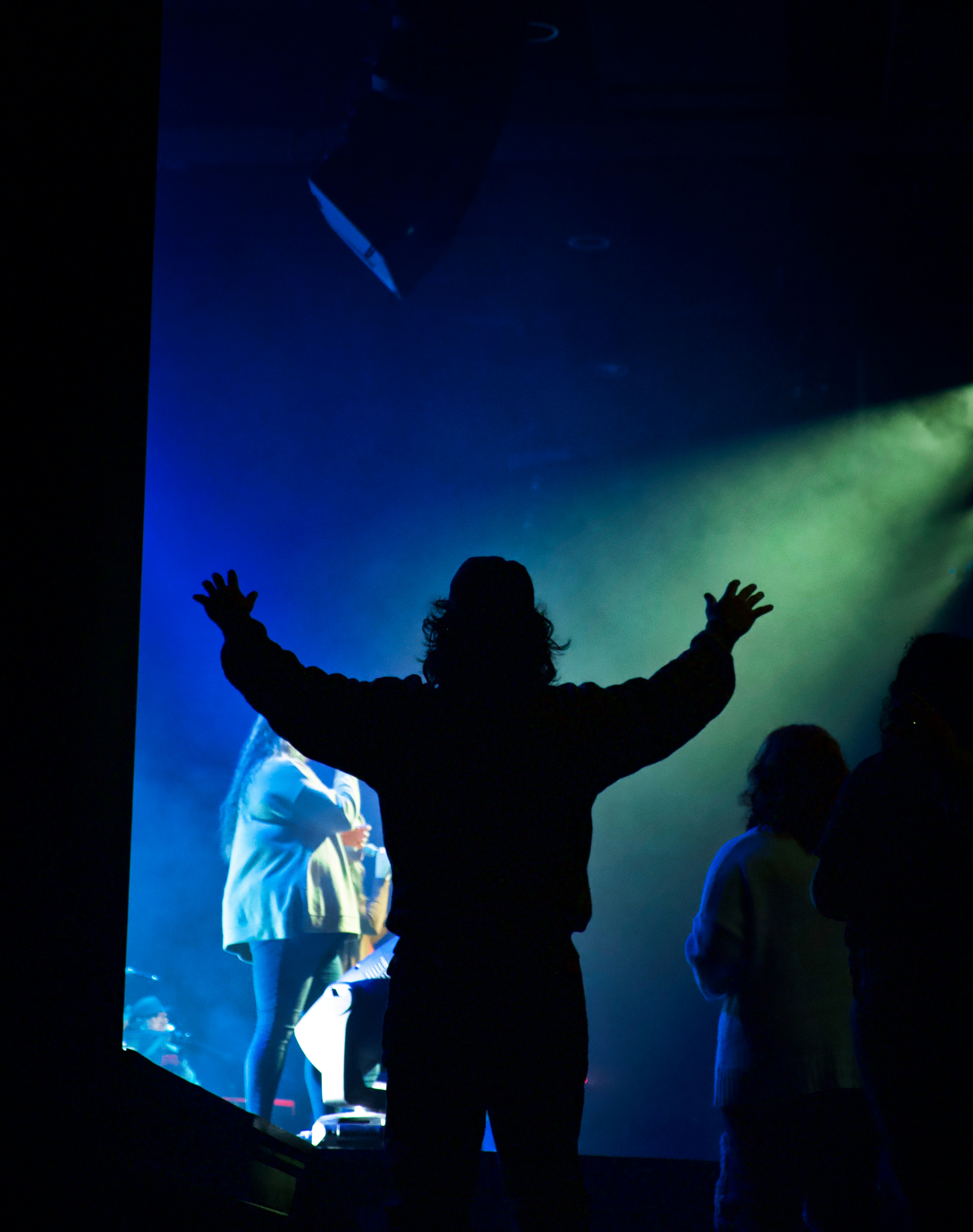 Stage manager raising arms and speaking to actors on stage